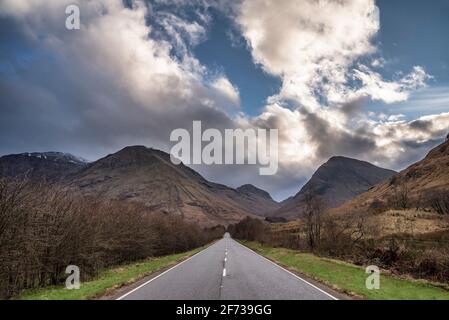 Atemberaubende Landschaftsaufnahme im Glencoe Valley in den schottischen Highlands Mit Bergketten in dramatischer Winterbeleuchtung Stockfoto