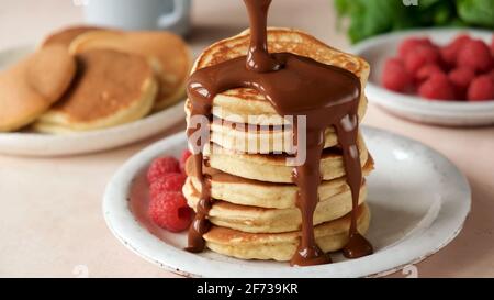 Pfannkuchen mit Schokoladensauce und Himbeeren auf einem Teller, süßes Frühstück Stockfoto