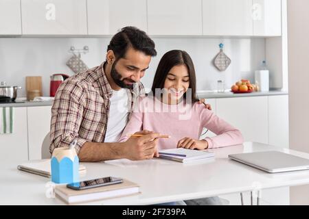 Glücklich indisch Vater hilft Schule Kind teen Tochter zu Hause lernen. Stockfoto