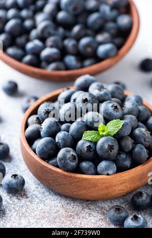 Frische Blaubeeren in einer Holzschale, Nahaufnahme. Gesunde Sommerbeeren Stockfoto