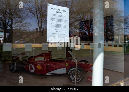 Ferrari F1 Grand Prix-Rennwagen in einem Autohaus in Colchester, Essex, Großbritannien, mit Hinweis auf Gebrauchtwagenbestand. Humor. Gegenüberstellung von Zeichen Stockfoto