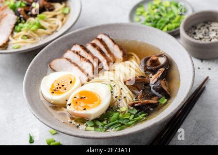 Ramen Sie Nudeln mit Huhn, Shiitake und Ei in einer Schüssel, Nahaufnahme. Asiatische Küche Stockfoto