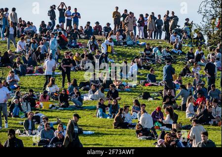 London, Großbritannien. April 2021. Massen auf Primrose Hill an einem sonnigen ostersonntagabend unter der lockern Sperre und im Großen und Ganzen nach der Regel der sechs. Kredit: Guy Bell/Alamy Live Nachrichten Stockfoto