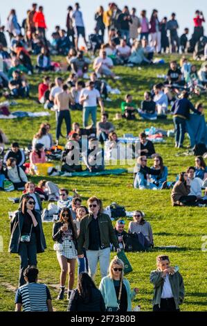 London, Großbritannien. April 2021. Massen auf Primrose Hill an einem sonnigen ostersonntagabend unter der lockern Sperre und im Großen und Ganzen nach der Regel der sechs. Kredit: Guy Bell/Alamy Live Nachrichten Stockfoto