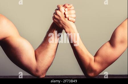 Arm Wrestling dünne Hand und ein großer starker Arm im Studio. Zwei Männerhände umspannten Arm Wrestling, stark und schwach, ungleich Stockfoto