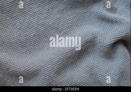 Struktur eines grau-blauen Wollpullovers. Fabric-Hintergrund. Stockfoto