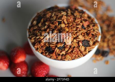 Erdbeergranola. Frühstück mit Milch oder Joghurt. Oder als gesunder Snack. Aufgenommen auf weißem Hintergrund Stockfoto