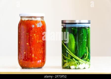 Gläser gefüllt mit Tomatensauce und eingelegten Gurken Stockfoto