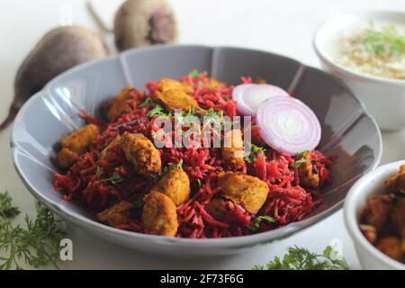 Rote Beete Pulao, ein ein-Topf-Reiszubereitung mit Basmati-Reis, Rote Beete, Zwiebeln und Gewürzen. Serviert mit luftgebratenen Hähnchenbissen und Quark. Auf Weiß geschossen Stockfoto