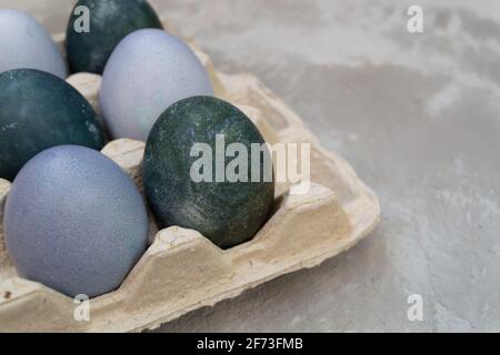 Eier in einem Karton sind mit natürlichen Farbstoffen bemalt: Rotkohl und Hibiskustee. Ostern Stockfoto