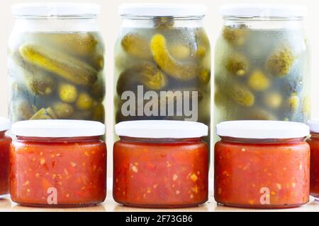 Gläser gefüllt mit Tomatensauce und eingelegten Gurken Stockfoto