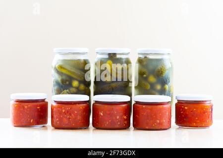 Gläser gefüllt mit Tomatensauce und eingelegten Gurken Stockfoto