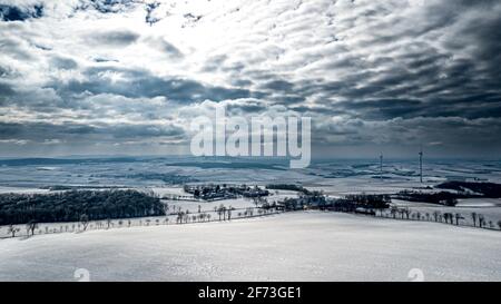 Verschneite Winterlandschaft Mit Abgelegener Siedlungen Und Windenergieanlagen In Österreich Stockfoto