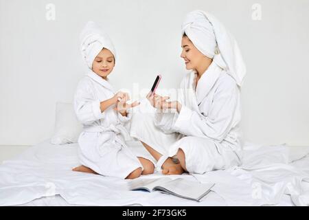 Mutter und Tochter halten Nagelfeile und machen Maniküre