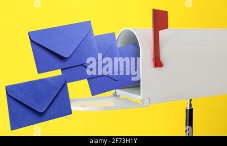 Briefkasten mit fliegenden Buchstaben auf farbigem Hintergrund Stockfoto