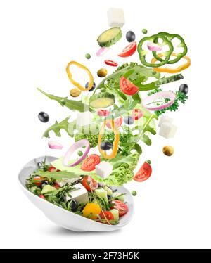 Schüssel mit gesundem Salat und fliegenden Zutaten auf weißem Hintergrund Stockfoto