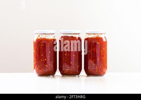 Gläser gefüllt mit Tomatensauce Stockfoto