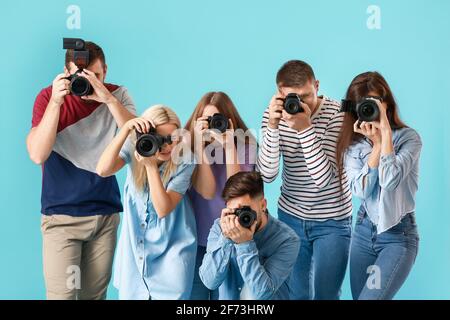Gruppe junger Fotografen auf farbigem Hintergrund Stockfoto