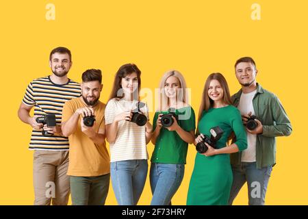 Gruppe junger Fotografen auf farbigem Hintergrund Stockfoto