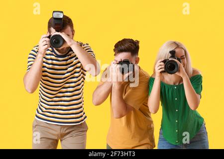 Gruppe junger Fotografen auf farbigem Hintergrund Stockfoto