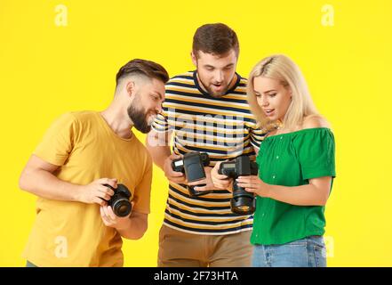 Gruppe junger Fotografen auf farbigem Hintergrund Stockfoto