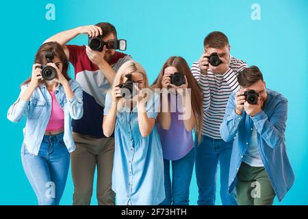Gruppe junger Fotografen auf farbigem Hintergrund Stockfoto
