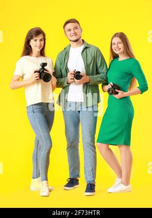 Gruppe junger Fotografen auf farbigem Hintergrund Stockfoto