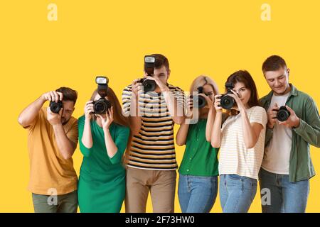 Gruppe junger Fotografen auf farbigem Hintergrund Stockfoto