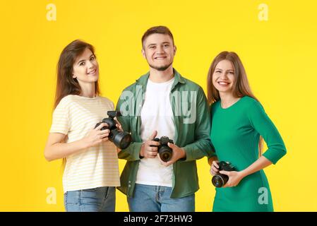 Gruppe junger Fotografen auf farbigem Hintergrund Stockfoto