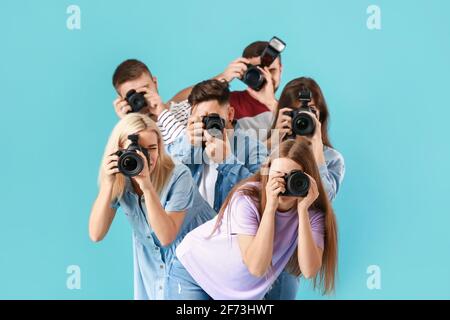 Gruppe junger Fotografen auf farbigem Hintergrund Stockfoto