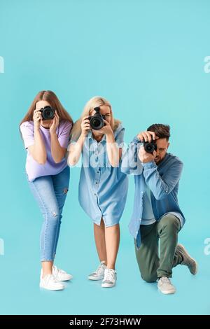 Gruppe junger Fotografen auf farbigem Hintergrund Stockfoto