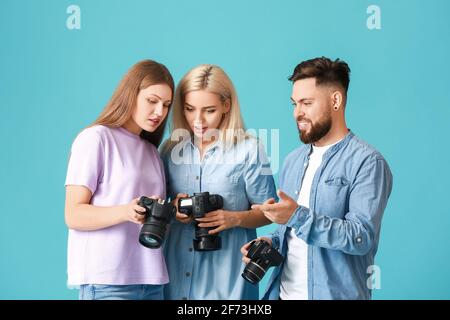Gruppe junger Fotografen auf farbigem Hintergrund Stockfoto
