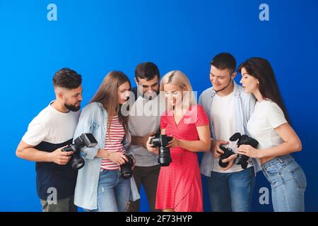 Gruppe junger Fotografen auf farbigem Hintergrund Stockfoto