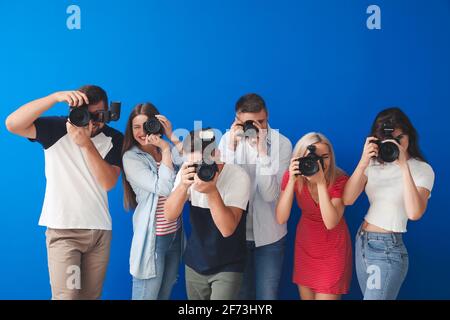 Gruppe junger Fotografen auf farbigem Hintergrund Stockfoto