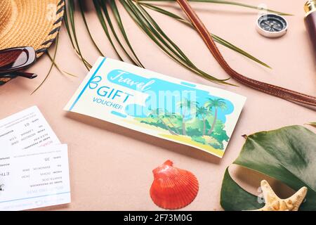 Set mit Reisezubehör und Geschenkgutschein auf farbigem Hintergrund Stockfoto