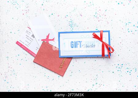 Reisegutschein und Reisepass mit Tickets auf hellem Hintergrund Stockfoto