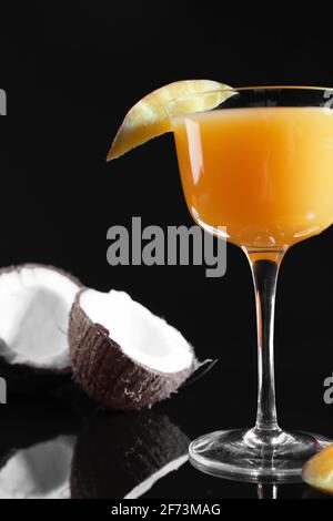Ein Glas leckere Mango margarita und Kokosnuss auf dunklem Hintergrund Stockfoto