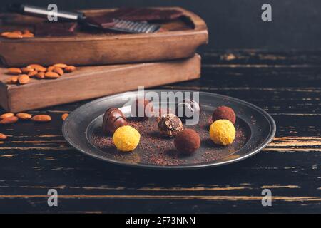Teller mit süßen Schokoladen-Bonbons auf Holzhintergrund Stockfoto