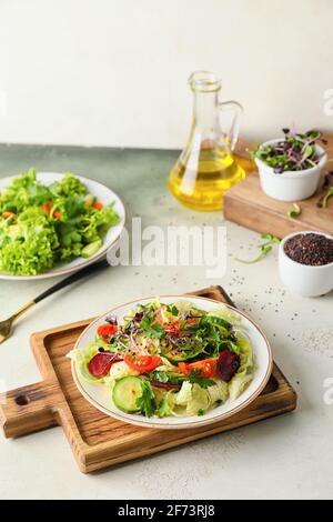 Teller mit frischem Salat und Gemüse auf dem Tisch Stockfoto
