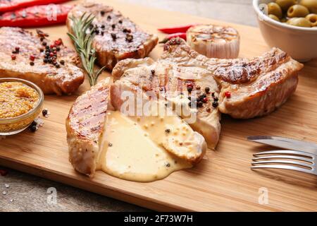 Tafel mit leckeren Steaks mit Gewürzen und Sauce, Nahaufnahme Stockfoto