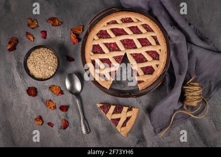 Draufsicht auf hausgemachten Kuchen namens 'Linzer Torte', ein traditionelles österreichisches Shortcake-Gebäck mit Obstkonserven und gemahlenen Nüssen mit Gitterdessig Stockfoto