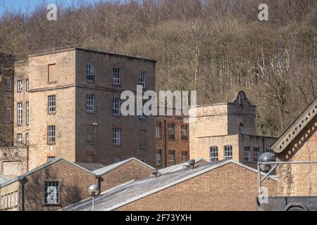 Verlassene alte 1800 industrielle Revolution Baumwollmühle außen. Hohe viktorianische Steingebäude mit Fenstern. Stockfoto