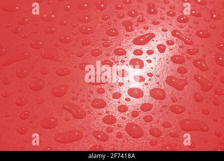 Pop Art surreal Stil rot gefärbte Wassertröpfchen auf dem Tischplatte nach dem Regen Stockfoto