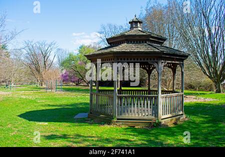 Holzpavillon in Rutgers Gardens vor einem Hintergrund von neuen Pflanzenwachstum an einem sonnigen Tag im Frühling -02 Stockfoto