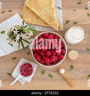 Nahaufnahme von frischen, reifen, roten Himbeeren auf einem Teller auf einem Tisch Stockfoto