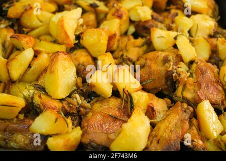 Schmackhaftes gebratenes Huhn und Kartoffeln aus der Nähe, fette Küche Stockfoto