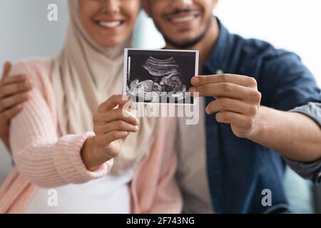 Nahaufnahme eines glücklichen, schwanger-muslimischen Paares, das eine Baby-Sonographie vorführt Foto Stockfoto