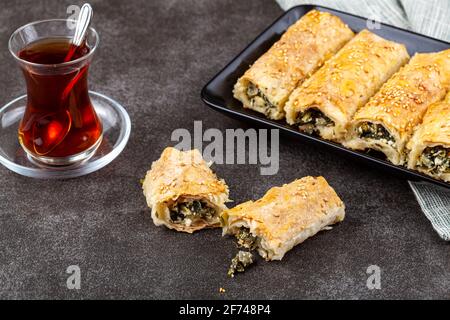 Traditionelle türkische Spinatbrötchen ( Ispanakli borek ) auf einem Porzellanteller serviert. Hausgemachte Rezept aus Spinat und Käse Füllungen insid gemacht Stockfoto