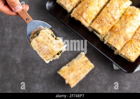 Traditionelle türkische Spinatbrötchen ( Ispanakli borek ) auf einem Porzellanteller serviert. Hausgemachte Rezept aus Spinat und Käse Füllungen insid gemacht Stockfoto