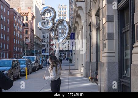 NEW YORK, NEW YORK - 3. APRIL: Eine Frau feiert am 3. April 2021 in New York City ihren 30. Geburtstag in den Washington Square Parks. Stockfoto